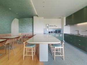 西条市にあるITOMACHI Hotel 0  (いとまちホテルゼロ）のキッチン(緑のキャビネット、テーブル、椅子付)