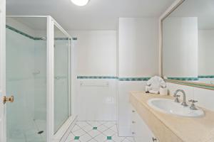 une salle de bain blanche avec un lavabo et une douche dans l'établissement The Moroccan - QStay, à Gold Coast 60 autres photos