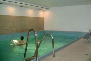 un homme nageant dans une piscine à côté d'un nageur dans l'établissement Haus-Ornum-1-OG-O-Wohnung-13, à Westerland