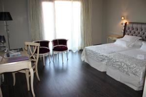 1 dormitorio con 1 cama, mesa y sillas en Hotel Spa Villa Nazules, en Chueca