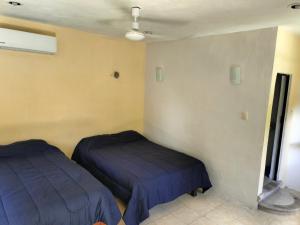 a bedroom with two beds in a room at Hotel la paloma in Izamal