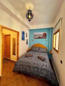une chambre avec un lit et un lustre dans l'établissement Entire Riad For Rent - Steps From Kasbah Museum, à Tanger