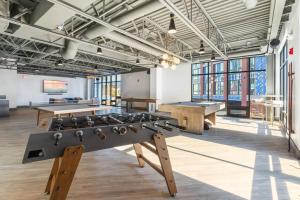 a large room with tables and ping pong tables at King Bed - Stunning Pier Views - Near Fishtown in Philadelphia