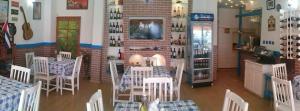 a restaurant with tables and chairs in a room at Family Hotel White House in Pomorie
