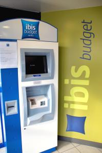 een geldautomaat naast een muur bij ibis budget Flers Grands Champs in Flers