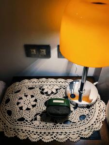 a bed with a table with a lamp on it at Through A Path in Tainan