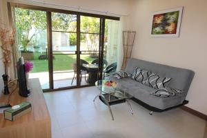 sala de estar con sofá y mesa de cristal en Babylon Pool Villas en Nai Harn Beach