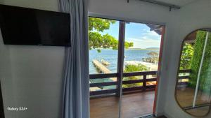 a room with a window with a view of the ocean at Refugio Bela Ilha Luxo Casal Acesso por Barco in Florianópolis