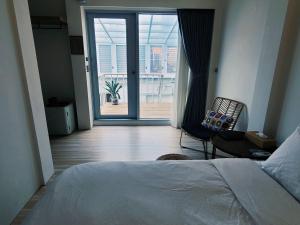 a bedroom with a bed and a view of a patio at Through A Path in Tainan