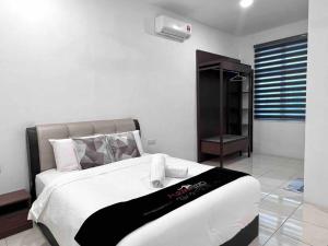 a bedroom with a bed with a black and white blanket at OV 4 bedrooms, family 10-14 pax homestay in Ulu Melaka