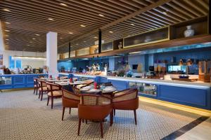 a restaurant with a long table and chairs and a bar at Sarovar Premiere Amritsar in Amritsar