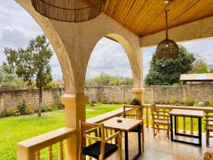an outdoor patio with tables and chairs and a fence at Starehe Villa in Arusha