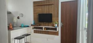 JandaíraにあるParaíso dos Coqueiros - Casa Bem-te-viのテレビ、キッチン(椅子付)が備わる客室です。