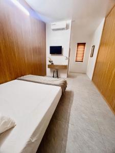 a bedroom with a large bed and a desk at Bảo Ngọc Motel in Làng Me