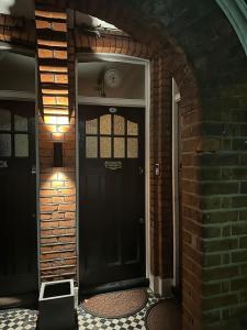 a black front door of a brick house at Modern Double bedroom in city apartment room 2 in London