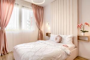 a bedroom with a white bed and a window at ARI - AFI Mall Luxurious Apartments with Free Parking in Arad
