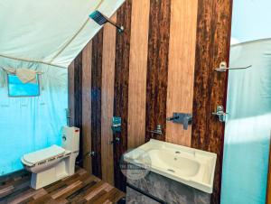 a bathroom with a toilet and a sink at Dawat-e-Drung by FrozenFall Resort in Gulmarg +59 photos