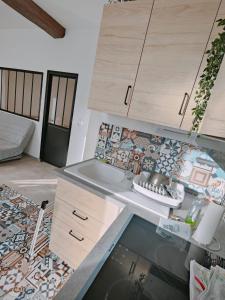 a kitchen with a sink and a counter top at Maisonnette - Charme Cœur de Vigne in Chenôve
