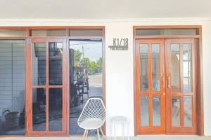 a building with two doors and a chair outside at RedDoorz at Anjasmoro Guest House near Bandara Ahmad Yani Semarang in Kalibanteng-lor