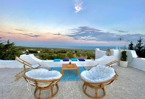 Un patio con mesa y sillas y el mar. en Yogargano, en Monte SantʼAngelo