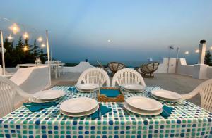 una mesa con un mantel y sillas de color azul y blanco en Yogargano, en Monte SantʼAngelo 1 foto más