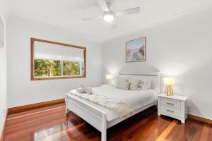 Un dormitorio blanco con una cama blanca y una ventana. en Sandlewood Breeze - Pet Friendly - Community Pool, en Callala Beach 17 fotos más