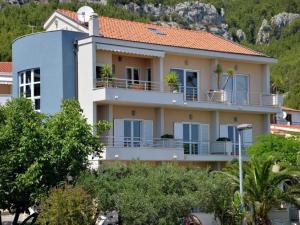 un gran edificio de apartamentos con balcones y árboles en Apartments Antonio - One Bedroom Apartment with Balcony and Sea View - 3, en Tučepi