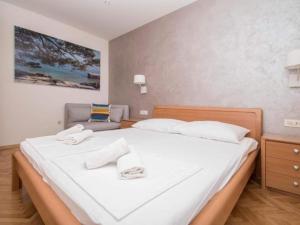 Un dormitorio con una gran cama blanca con toallas. en Apartments Antonio - One Bedroom Apartment with Balcony and Sea View - 3, en Tučepi 10 fotos más
