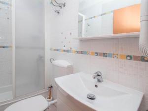 Un baño blanco con lavabo e inodoro. en Apartments Antonio - One Bedroom Apartment with Balcony and Sea View - 3, en Tučepi