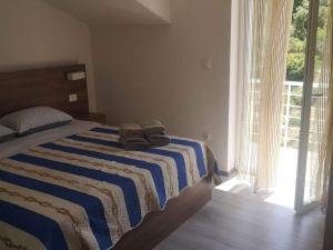 a bedroom with a bed with a striped blanket at Apartments Kalajzic- One Bedroom Apartment with Terrace A3 ST in Pučišća