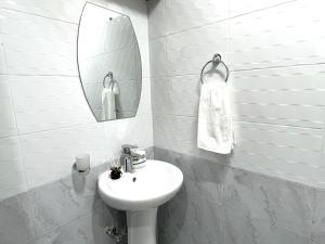 a white bathroom with a sink and a mirror at Naka Suites With Balcony, Amazing Lake View, GYM in Nakuru +9 photos