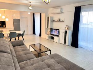 a living room with a couch and a table at Cozy Unique Penthouses with Terrace and Suceava Magic View in Suceava