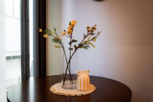 un jarrón con flores en él sentado en una mesa en The Alpha Nest Stylish 1BR in Central Wellington, en Wellington
