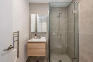 un baño con ducha y lavabo en The Alpha Nest Stylish 1BR in Central Wellington, en Wellington