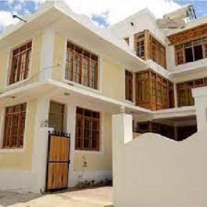 a large white house with a large building at Hotel DE Suzain-Leh in Leh