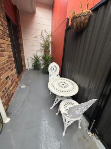 a patio with two chairs and a table at Garden Retreat House Sunnybank Hills in Brisbane