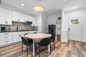 a kitchen with white cabinets and a table and chairs at Modern Cabin Oaklawn in 10 min Private Patio in Hot Springs