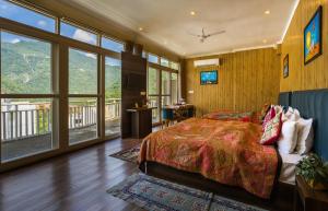 a bedroom with a bed and a large window at Tripli Hotels Ayushman Retreat in Rishīkesh