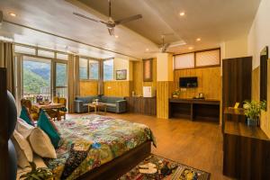 a bedroom with a bed and a living room at Tripli Hotels Ayushman Retreat in Rishīkesh