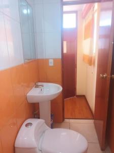 een badkamer met een witte wastafel en een toilet bij Hospedaje Vista al Lago in Puno