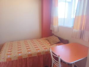 een kleine slaapkamer met een klein bed en een tafel bij Hospedaje Vista al Lago in Puno