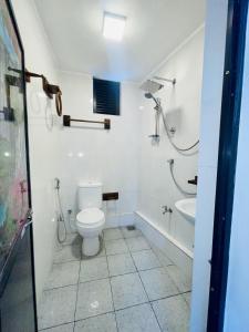 a white bathroom with a toilet and a sink at Villa Bellissimo - Hiriketiya in Dickwella
