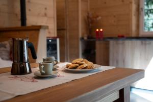 a table with two cups and two plates of cookies at Angolo del Bosco in Pila +23 photos