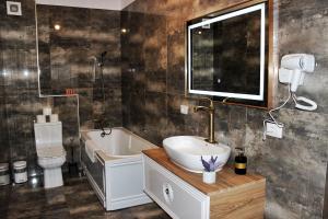 a bathroom with a sink and a tub and a toilet at Book your Luxury Cozy Apartment in City Center Suceava in Suceava +5 photos