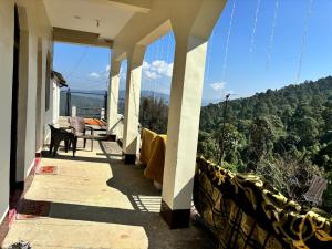 a balcony of a house with a view of trees at VILLAGE SUKOON HOME STAy in Rānīkhet +15 photos