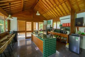 a large kitchen with wooden ceilings and a green counter top at Pool & Jungle View Family Room in Kaba-Kaba in Tabanan
