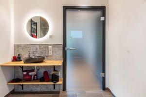 a glass door in a bathroom with a sink at Kapellenhof Ferienwohnungen in Triberg +68 photos