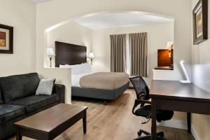 a hotel room with a bed and a desk at Quality Inn & Suites Lafayette in Lafayette