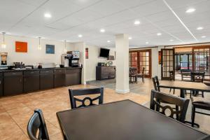 a living room with a table and chairs and a kitchen at Quality Inn & Suites Lafayette in Lafayette