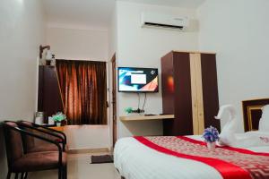 a hotel room with a bed and a television at Hotel RD in Perundurai